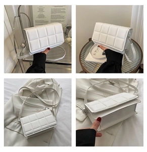 Detail view of a white quilted crossbody bag showing square stitching and slim strap