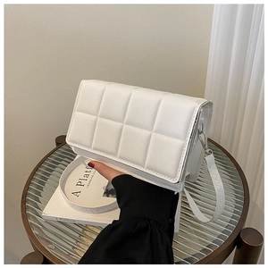 Close-up of white quilted leather square crossbody bag with silver metal hardware details