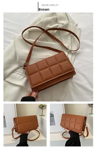 Detail of brown quilted PU leather crossbody bag with square stitching and silver buckle