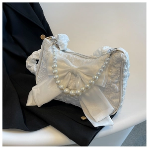 Detail of white bubble pleated cloud bag with organza bow and pearl chain handle