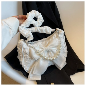 Detail of white pleated cloud bag with organza bow and pearl chain handle