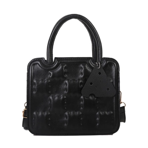 Fashionable black square handbag with embossed pattern and cheese pendant accessory