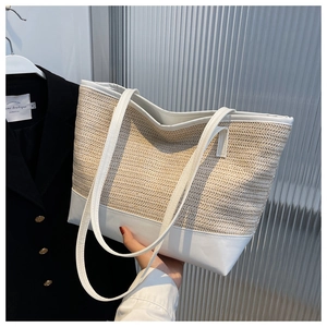 Detail of summer straw tote bag featuring beige weave and white leather patchwork finish