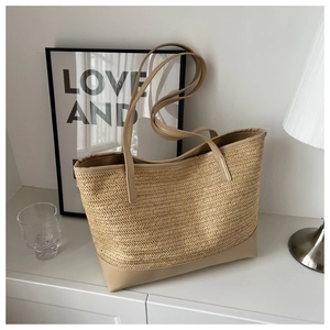 Detail of herringbone woven straw tote bag with premium khaki leather base and straps