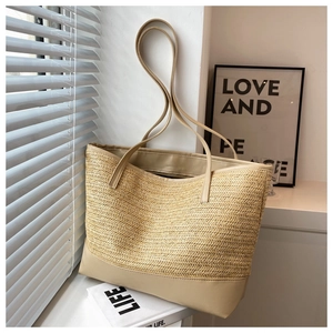 Close-up of woven straw texture and premium khaki leather trim on large tote bag