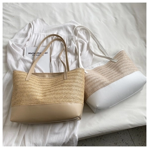 Close-up of woven straw tote bags in beige and white with premium leather strap detail