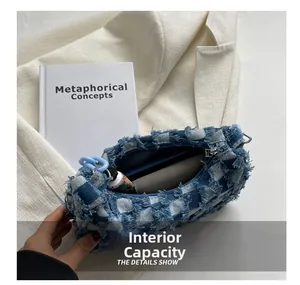 Detailweergave van de denim dambordtas binneninhoud met blauwe ketting en franjes