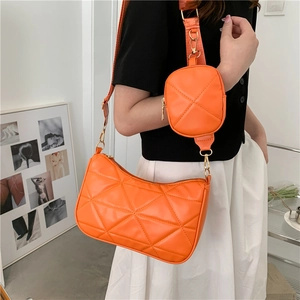 Leuchtend orangefarbene Stepptasche mit kleinem Rundbeutel und goldenen Metallelementen
