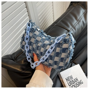 Detailopname van blauwe dambord denim tas met franjestas met blauwe hars kettingriem