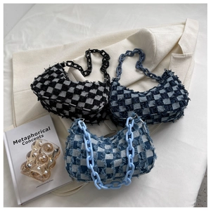 Detailopname van distressed denim hobo-tassen met ruitpatronen en dikke kettingen