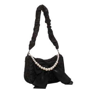 Black ruched shoulder bag featuring large satin bow and white pearl chain handle