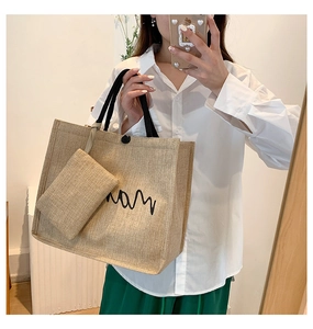 Detail of jute woven tote bag with artistic embroidery and matching mini pouch set