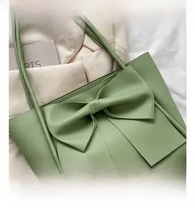 Détail du sac cabas en cuir PU vert avec un grand nœud et de fines bandoulières