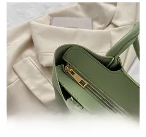 Détail de la fermeture éclair dorée sur le sac cabas en cuir vert sauge