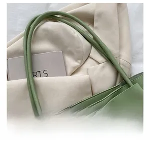 Gros plan des fines bandoulières d'un sac cabas vert clair avec grand nœud déco