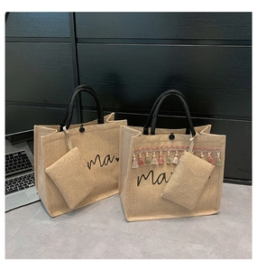 Close-up of jute tote bag set with mama print, tassels, and black rope handles