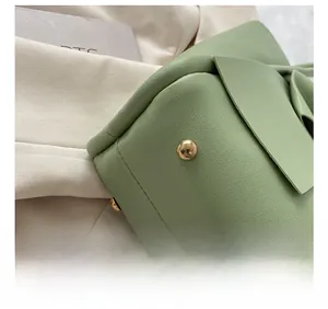 Vue détaillée du fond de sac en cuir vert avec clous de protection en métal doré