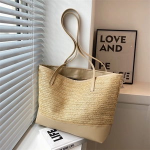 Large woven straw tote bag with leather trim and shoulder straps for summer beach travel