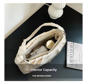 Detail view of woven handle shoulder bag showing spacious interior with cosmetic items