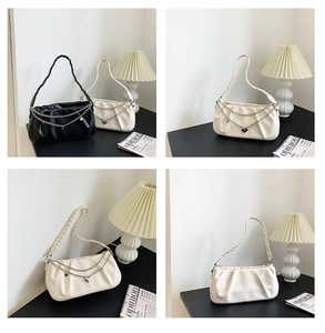 Detail view of ruched cloud bags featuring woven straps and silver heart chain charms