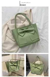 Détail du sac fourre-tout vert clair avec un grand nœud décoratif et coins métalliques