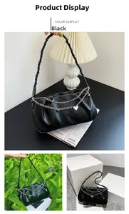 Detail of black faux leather underarm bag with silver chain and heart charm