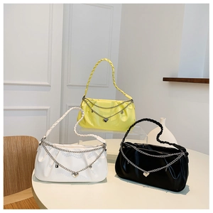 Detailed view of ruched shoulder bags in yellow, white, and black with heart chain