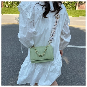 Detail of light green crossbody bag featuring vertical texture and ethnic embroidery strap