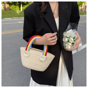 Chic beige woven beach tote with vibrant rainbow handles and boho tassel details