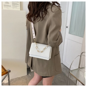 White pleated crossbody bag with ethnic embroidery strap and gold chain detail