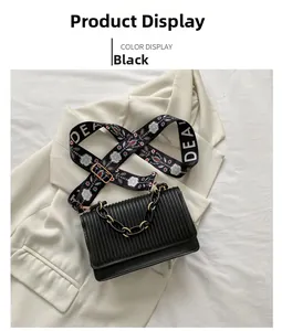 Detail view of black rectangular handbag with vertical pleated texture and daisy strap