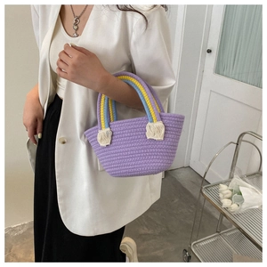 Detail of purple handmade woven tote bag with colorful handles and cream fringe accents
