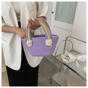 Detail of purple woven cotton tote bag with rainbow handles and white fringe tassels