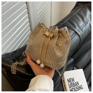 Detail van champagne strass emmertas met trekkoordsluiting en parelhangers