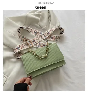 Detail of green pleated bag with gold chain and vintage floral embroidered strap