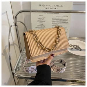 Close-up of pleated PU leather bag with chain handle and vintage jacquard strap