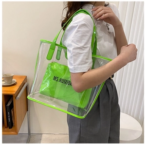 Detail shot of transparent PVC tote bag with fluorescent green inner pouch on model