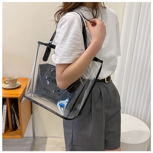 Detail view of large transparent PVC tote bag with black inner pouch and leather trim