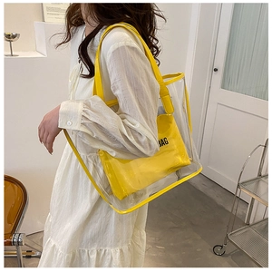 Close-up of bright yellow inner pouch with BAG letter logo inside transparent tote bag