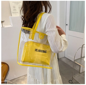 Close-up of clear PVC tote with yellow PU leather trim and matching inner pouch