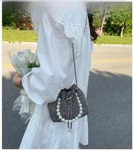 Detail of elegant black bucket bag with sparkling silver rhinestones and pearl handle