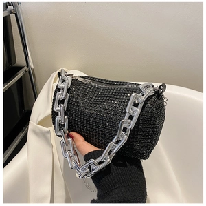 Detail of a sparkling black rhinestone bucket bag with chunky silver chain handle