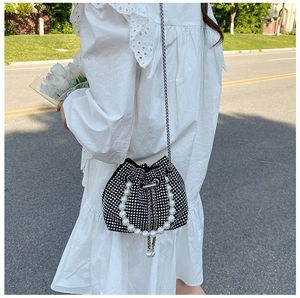 Détail du sac seau à strass scintillants avec anse en perles et bandoulière chaîne