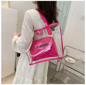 Close-up of clear PVC tote with rose red trim and inner pouch for summer beach use