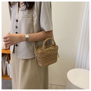 Detail of handmade straw bucket bag with hollow-out weave and drawstring inner pouch
