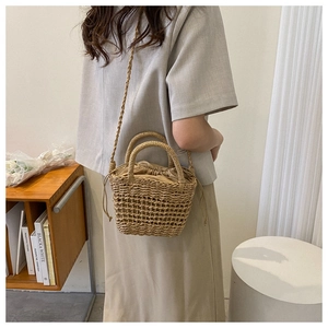Close-up of handmade hollow straw bucket bag with drawstring liner and round handles