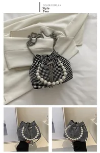 Close-up of black drawstring bucket bag with sparkling rhinestones and pearl handle
