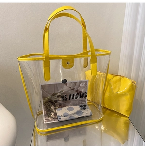 Detail view of large transparent PVC tote bag with yellow leather trim and inner pouch