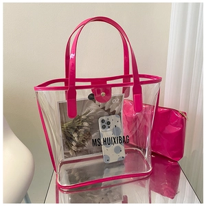 Detail of transparent PVC tote bag set with vibrant magenta glossy trim and inner pouch