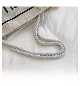Close-up of durable woven rope handle and high-density canvas texture with metal rings